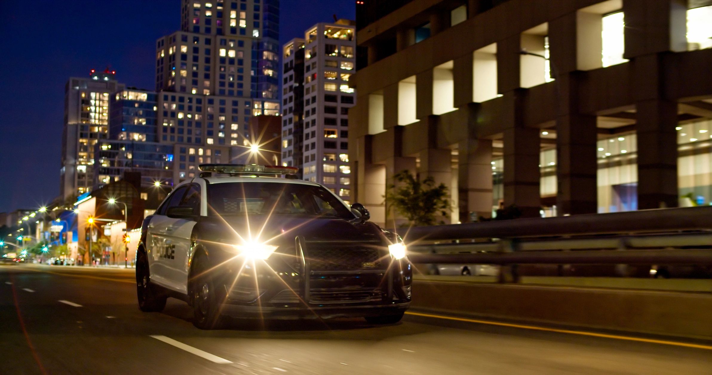 Luxury vehicle traveling through a city at night